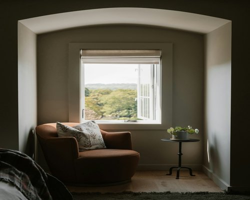 A well-lit cozy reading corner with a comfortable chair and natural window light